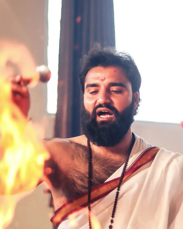 Yogi Arya chanting beside the sacred fire during a havan ceremony