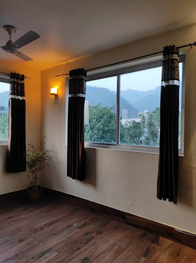 The practice hall at dusk with windows looking onto forested hills