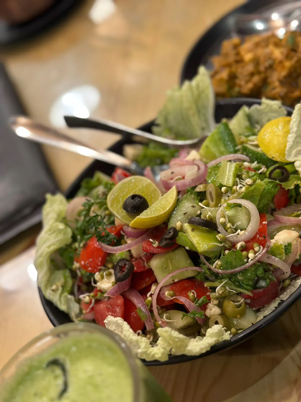 A colourful sprout salad in a black bowl